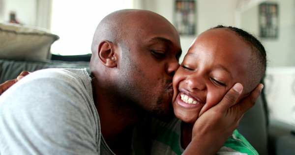 dad kissing child on cheek