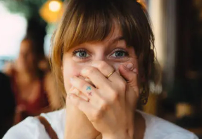 hands covering mouth
