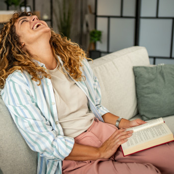 woman laughing while reading